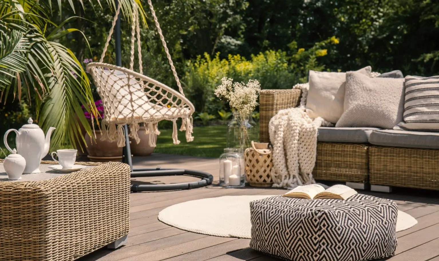 A rattan lounge set with cushions on a sunny garden deck