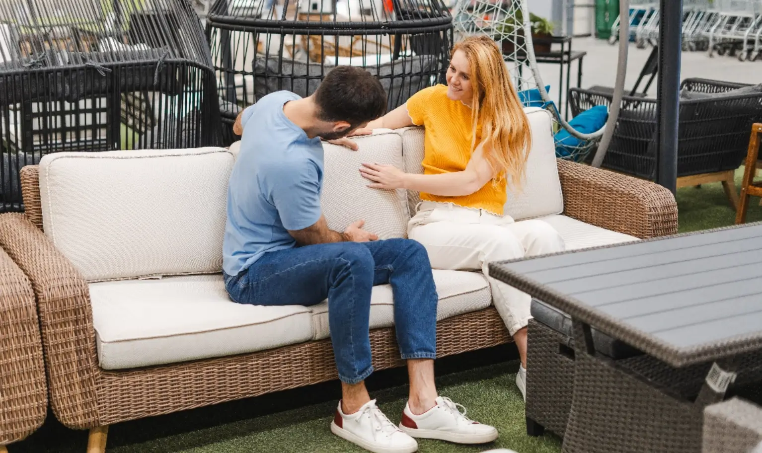 A couple relaxing on a garden sofa set